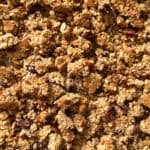 Close-up of chunky granola clusters featuring oats, nuts, and seeds baked to a golden brown, with visible pieces of almonds and pecans throughout—perfect inspiration for how to make homemade granola.