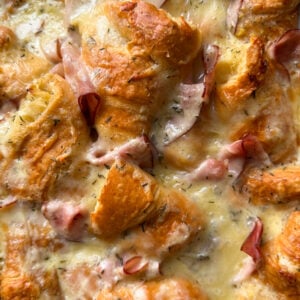 Golden, flaky croissant pieces baked with melted cheese, herbs, and slices of ham create a savory Ham and cheese croissant bake—an ideal Christmas morning breakfast.