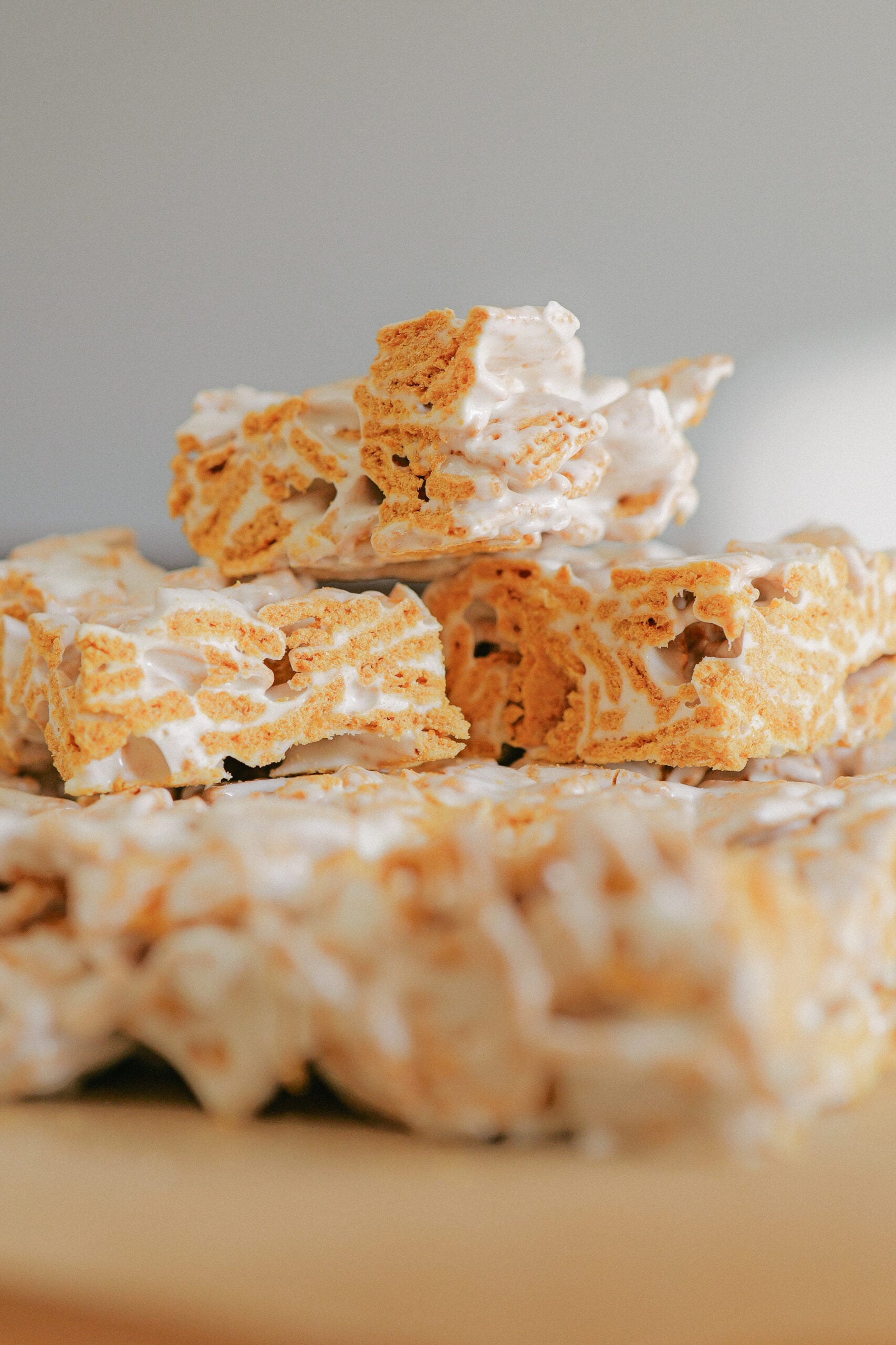 Squares made from frosted mini wheat cereal and golden grahams cereal, held together by a glossy, white marshmallow coating, arranged in a grid and cut into perfectly sized marshmallow treats.